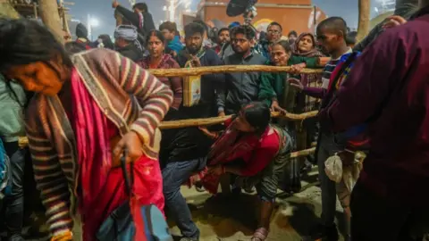 Families search for missing relatives after at least 12 feared dead in crush at Kumbh Mela festival.